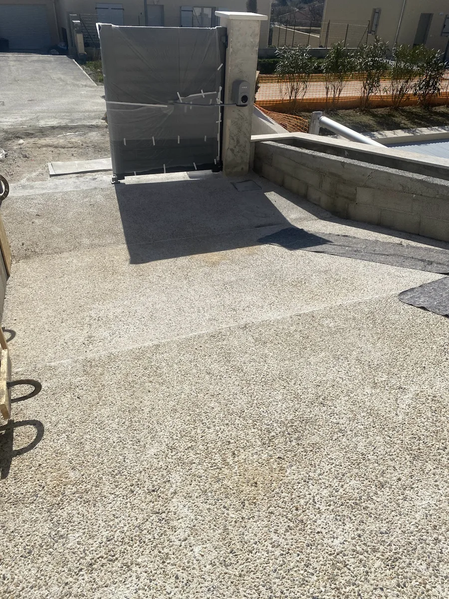 Cour en béton désactivé avec muret maçonné