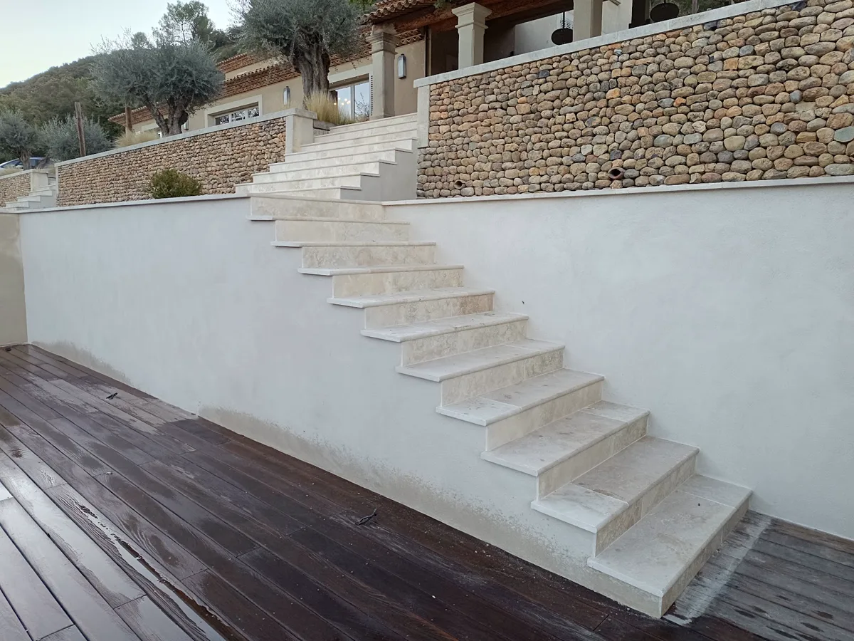Escalier extérieur maçonné le long d'un mur en galets