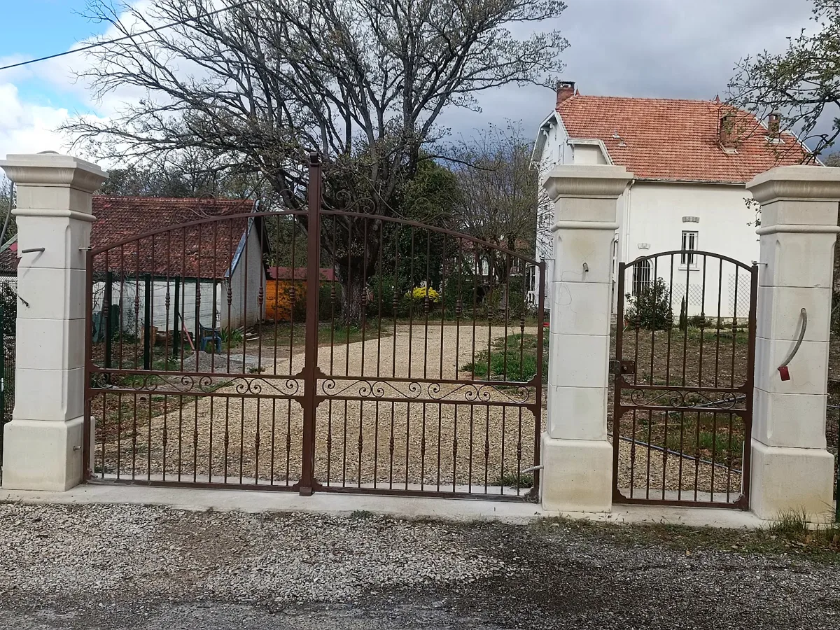 Piliers de portail maçonnés avec portail en fer forgé