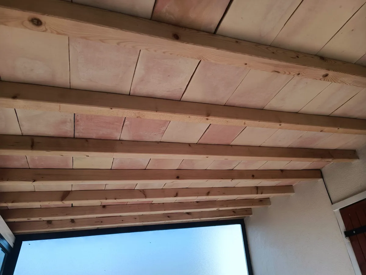Plafond rénové avec poutres en bois apparentes