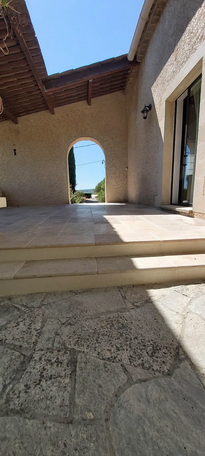 Terrasse en pierre sous une arche maçonnée