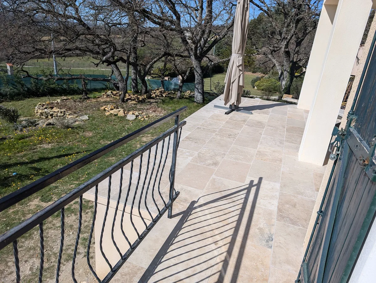 Terrasse en travertin avec garde-corps en fer forgé